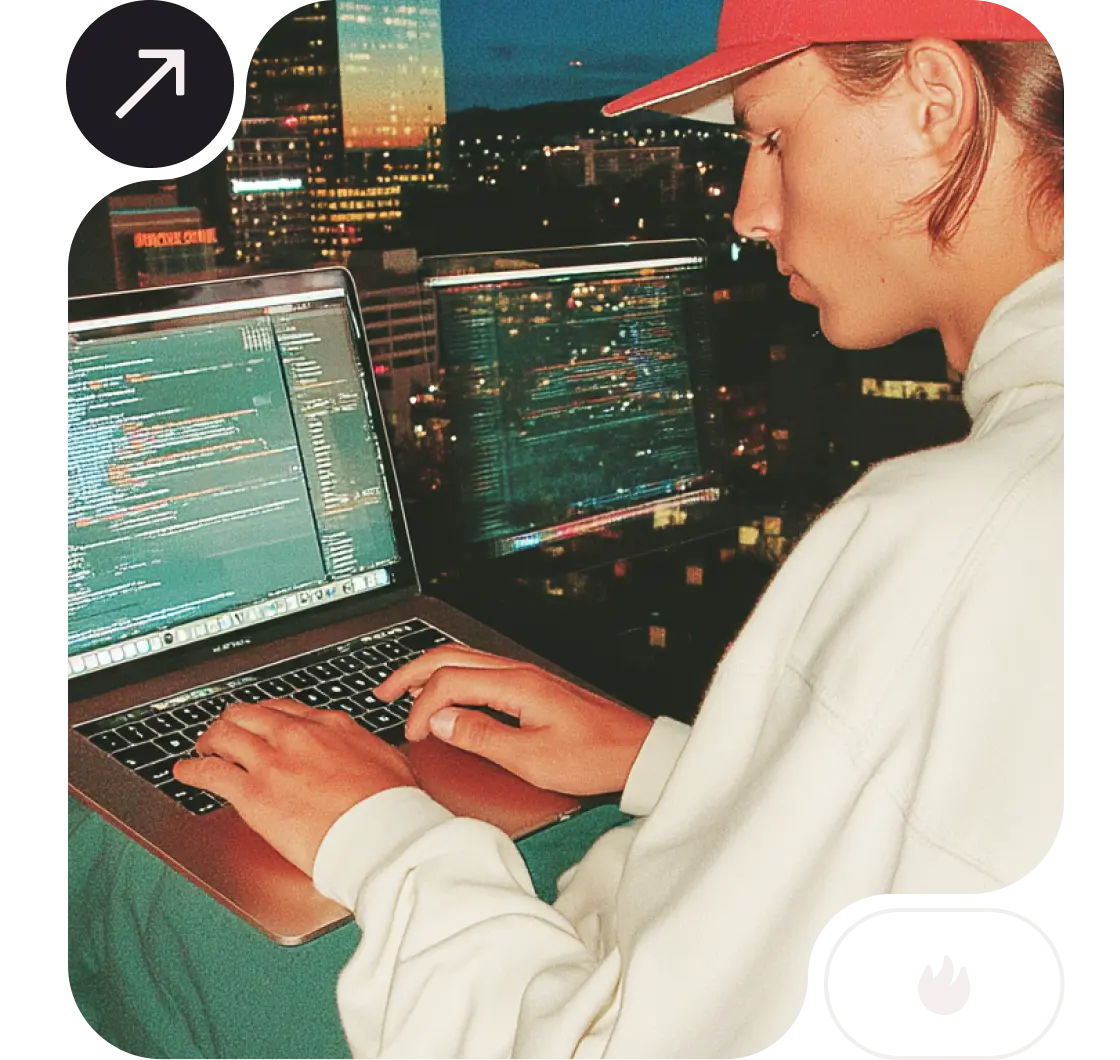 Guy sit close to a large window coding on his laptop